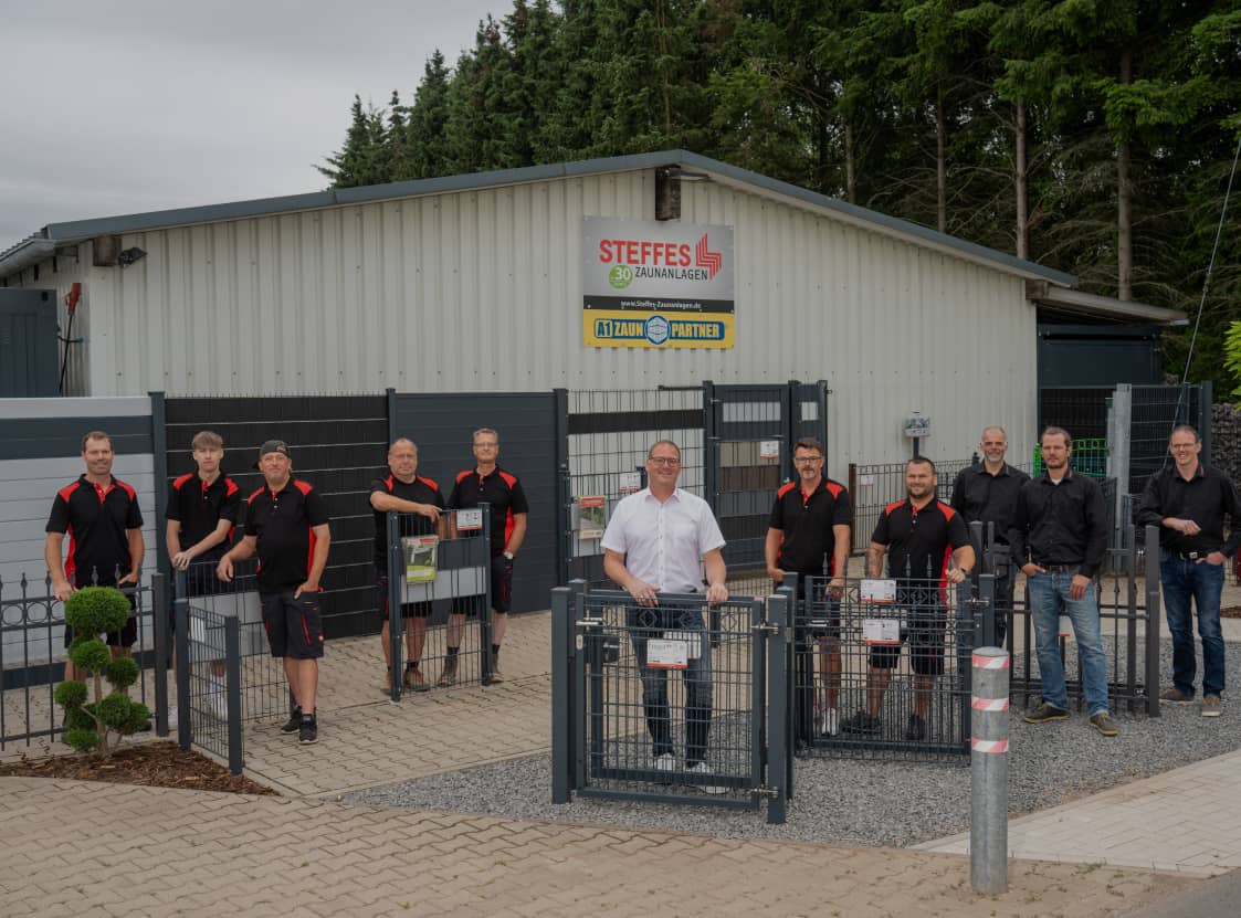 Team Foto der Mitarbeiter von Steffes Zaunanlagen vor der Firmenhalle