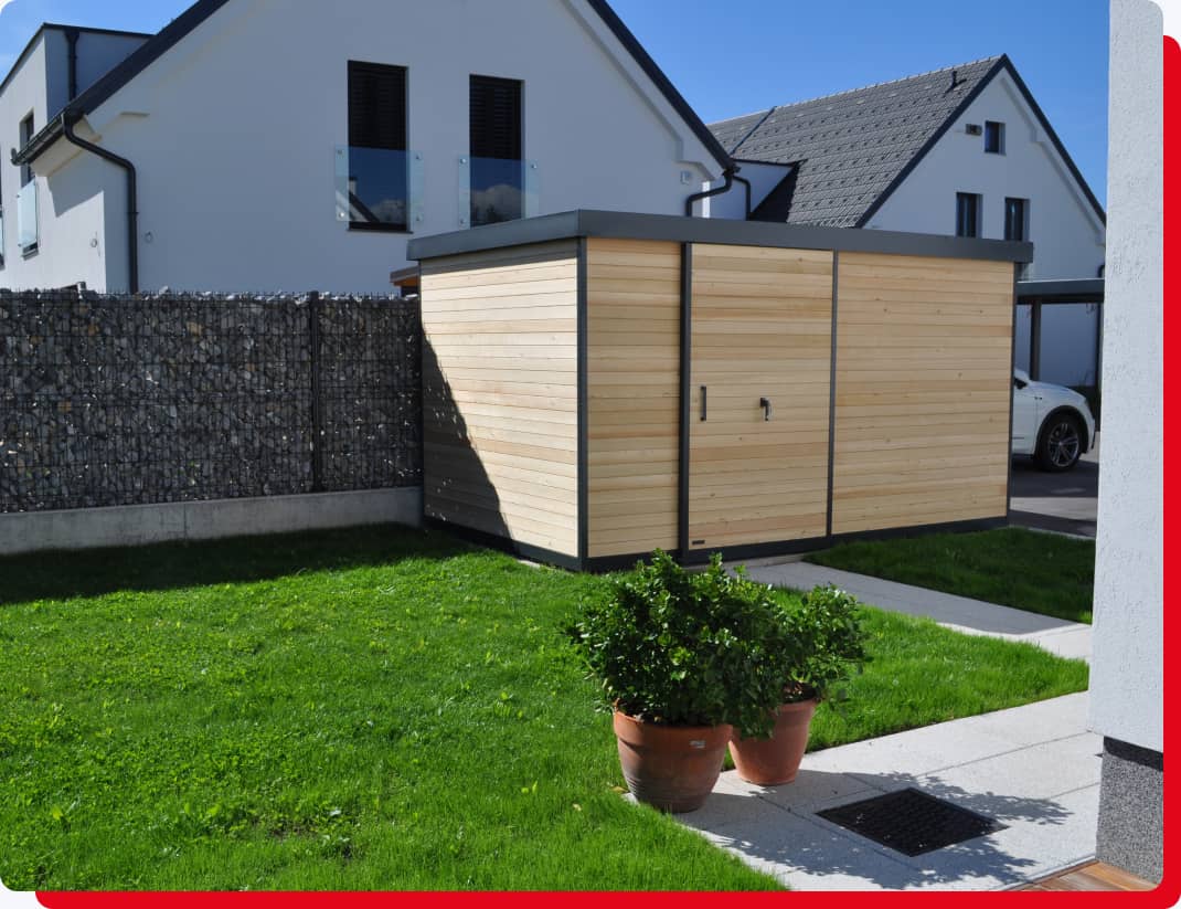 Gartenhaus in Holzoptik vor Steingabionen und Einfamilienhäuser im Hintergrund